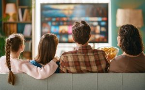 Family watching IPTV on a modern Smart TV in a living room
